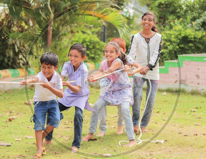 Group Of Multi Racial Children Playing Tug Of War Game Kindergarten - Multi Ethnic Kids Playing Outdoor Games Against Racism.