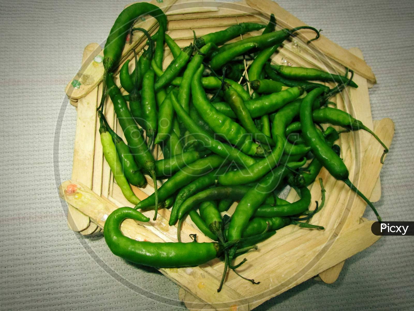 Hari Mirch in tokri , green chillies in wooden bowl