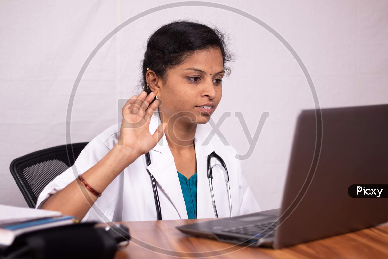 A Doctor Talking to Patients through a Video Call using a Laptop due to Corona Virus or COVID 19 Effect