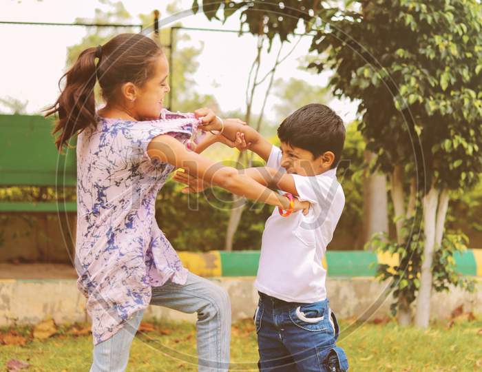 Two Little Siblings Fighting With Each Other At Park - Kids Hitting And Pulling Dress Due To Conflict At School.