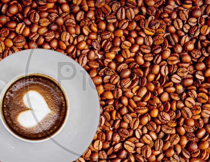 Coffee in a Cup with Coffee beans Background