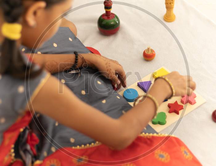 Cute Little Child Girl Playing With Indian Wooden Channapatna Toys In The Room