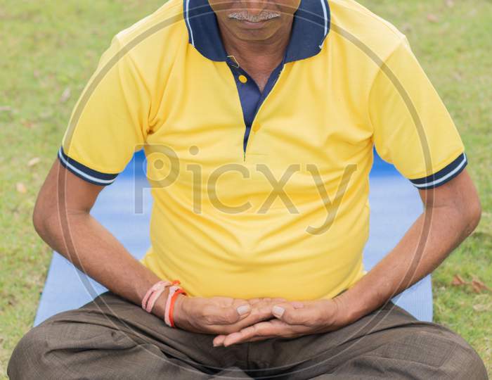 Elderly Man Or Old Man Doing Yoga as pert of Fitness Routine At Outdoor