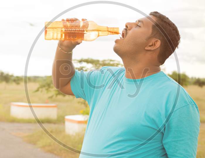 A Tired Man Drinking water after A Running Activity or Fitness Activity