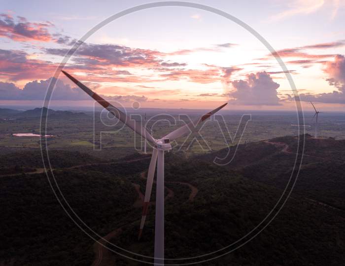 Aerial shot of windmills during sunset- close up