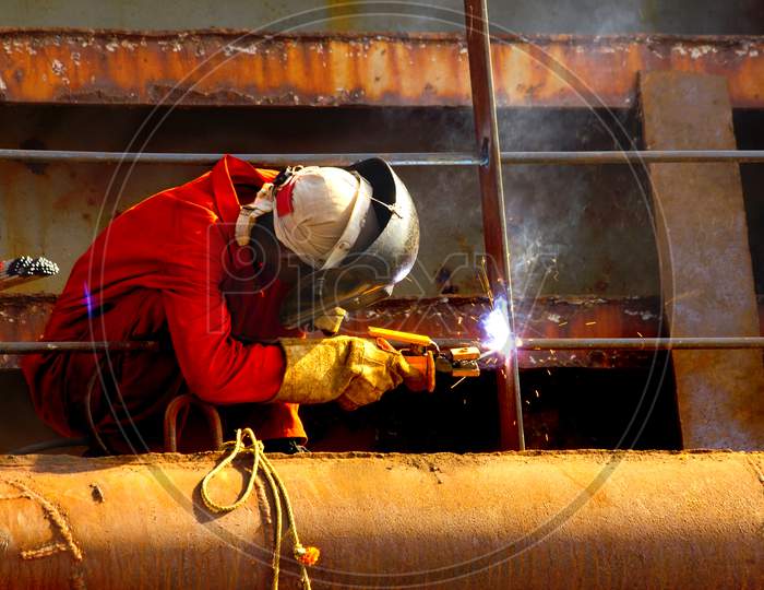 A Worker doing welding with a Helmet on