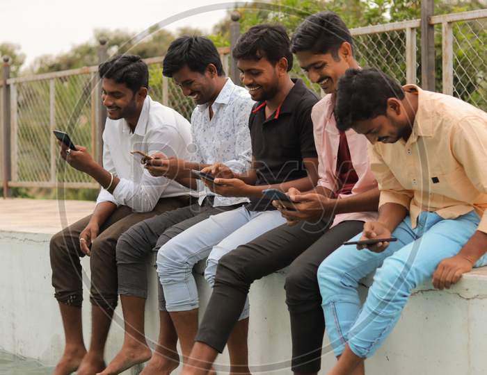 Group of College Students using mobile phones or Smartphones At College - Education, Learning Student, People Concept