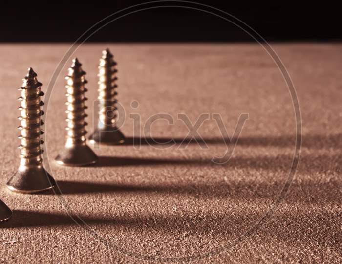 Screws with their shadows pointing on the right.