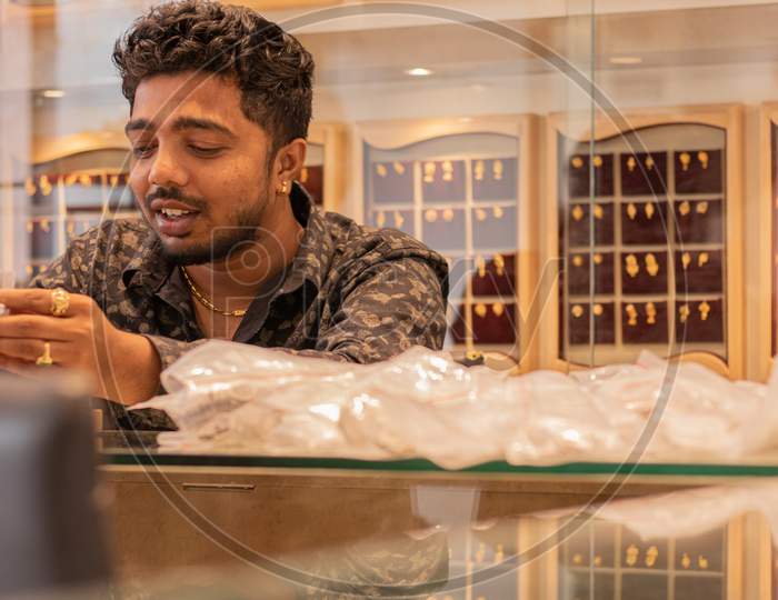 A Young Man/Person viewing Jewels in a Jewellery Shop