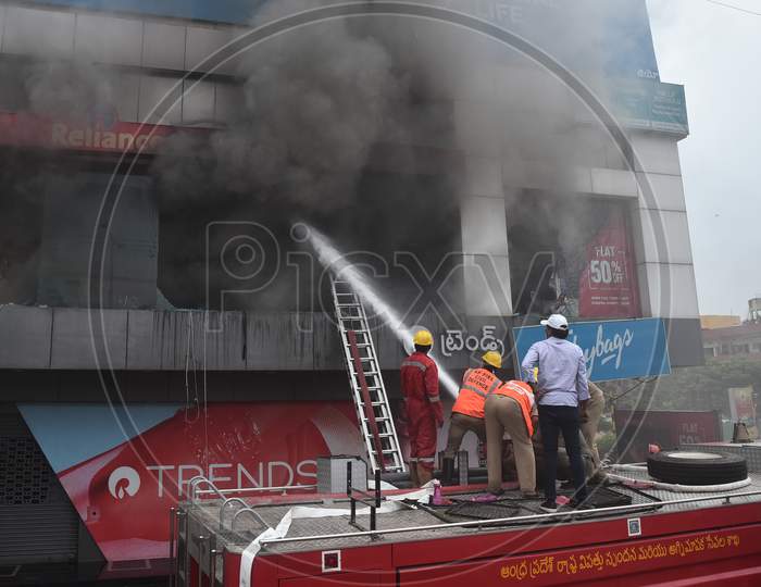 Firefighters douse a fire that broke out at a Reliance Trends store, during the fifth phase of coronavirus lockdown in Vijayawada.