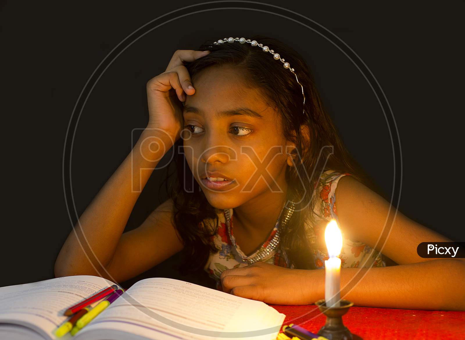 Portrait of a Kid with Books and Candle in the foreground