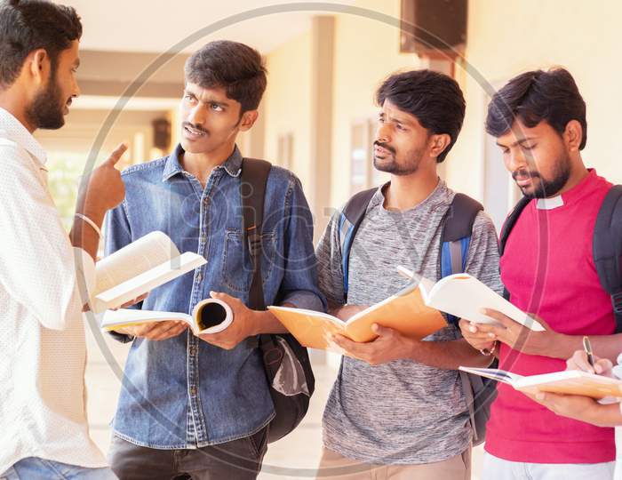 Group Of Students Listening To Senior Student To Clear Doubts - Young Intelligent Man Explaining To His Classmates By Looking Into Books At College - Education, Learning Student, People Concept