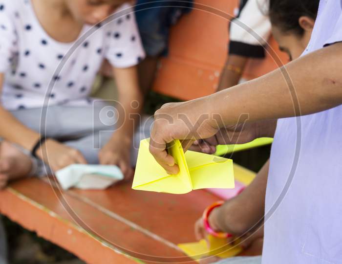 Children's Making Paper Rockets to Play Paper Rockets Game At a Park, Outdoors - Kids Playing Outside During Leisure.