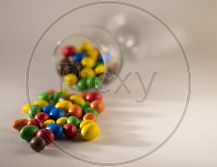 Multicolor chocolate candy or candy balls scattered on a white background.