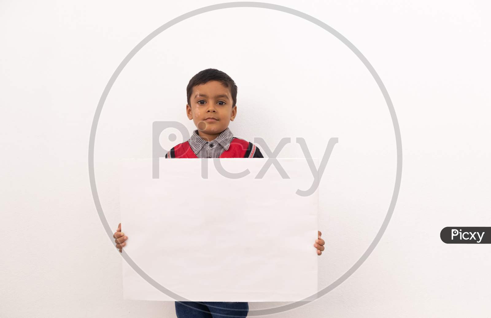 Concept Of Child Protest Showing With Young Boy Holding Large White Placard On Isolated Background.