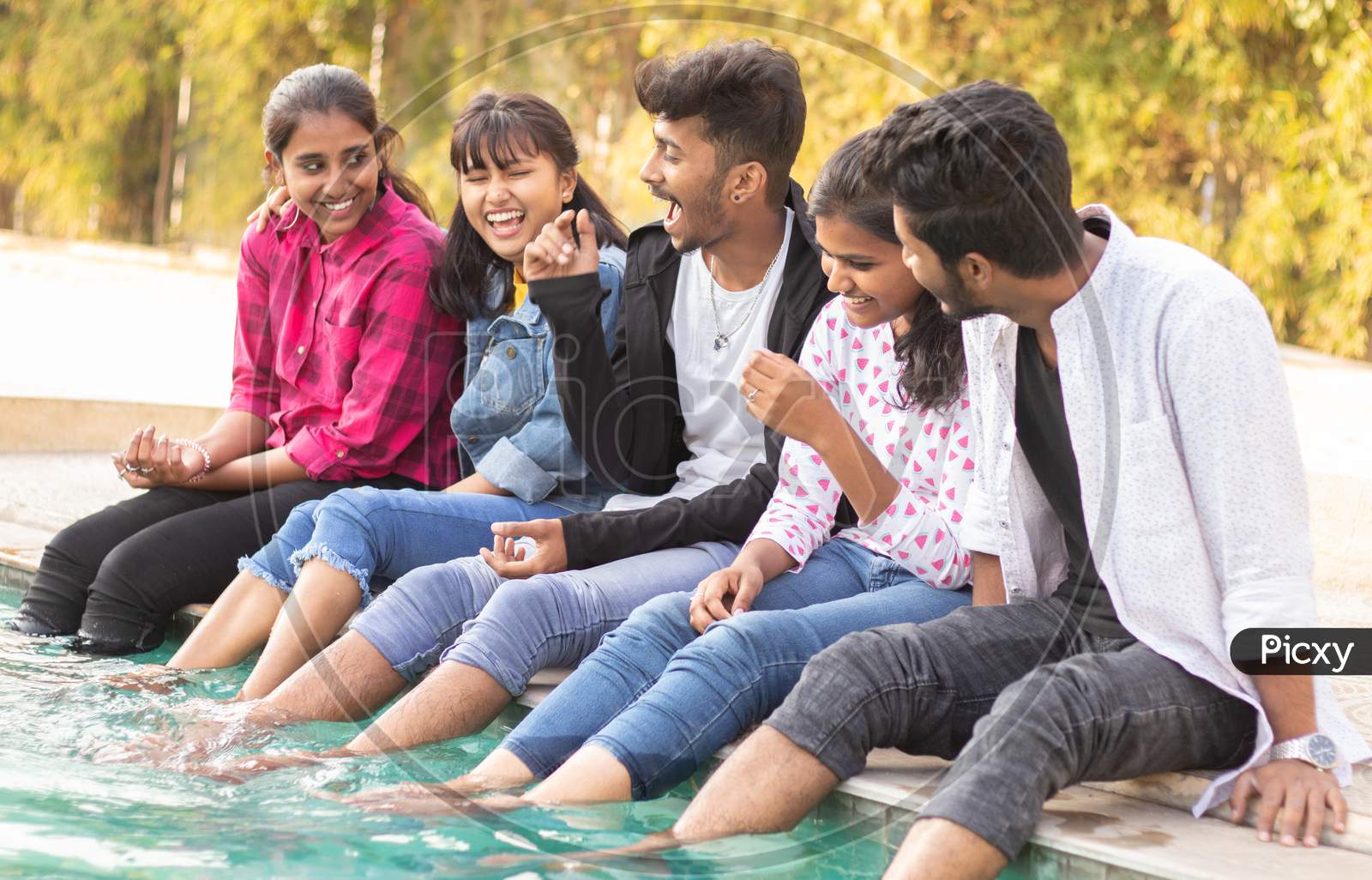 A Group of Happy Young People Talking to each other At Outdoors in a Pool
