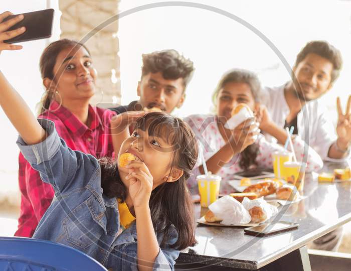 A Group of Happy Young People taking Selfies While having their Food