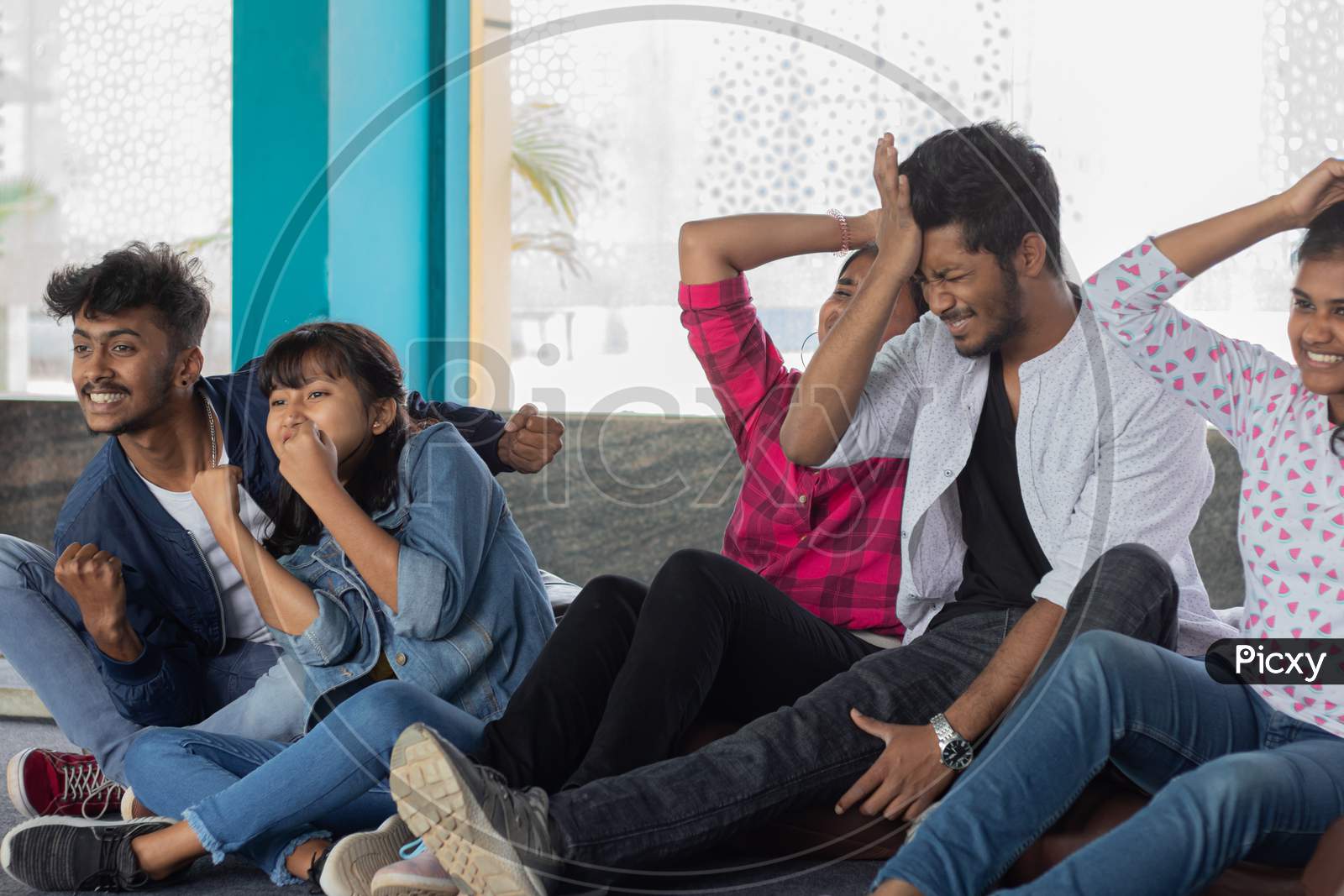 A Group of Happy Young People watching Television in Worried Mood