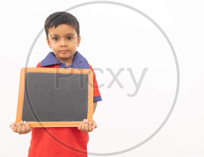 Concept Of Child Protest Showing With Young Boy Holding Black Slate On Isolated Background.