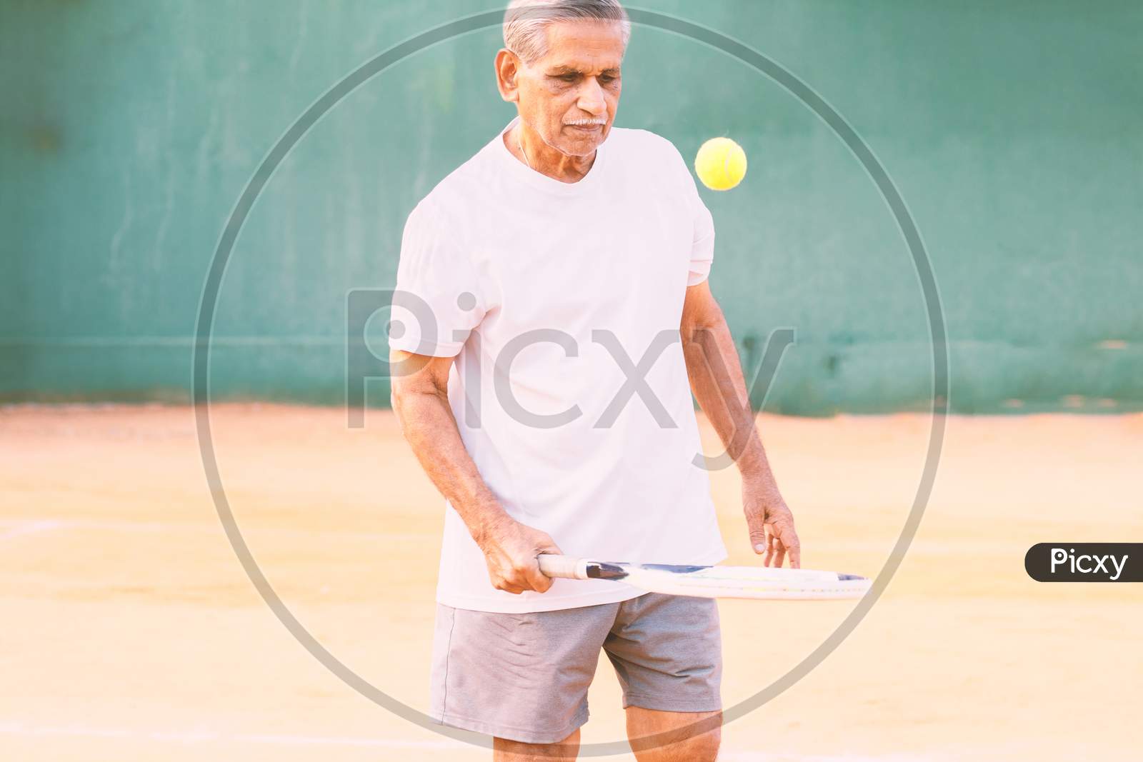 Elderly Man Playing Tennis - Concept Of Healthy And Fit Old People - Senior Player Practicing Tennis.