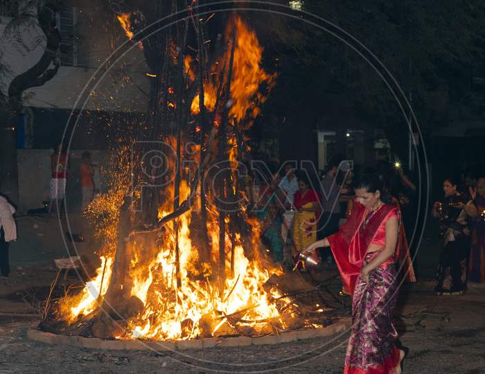 Woman walking barefoot around a ceremonial bonfire