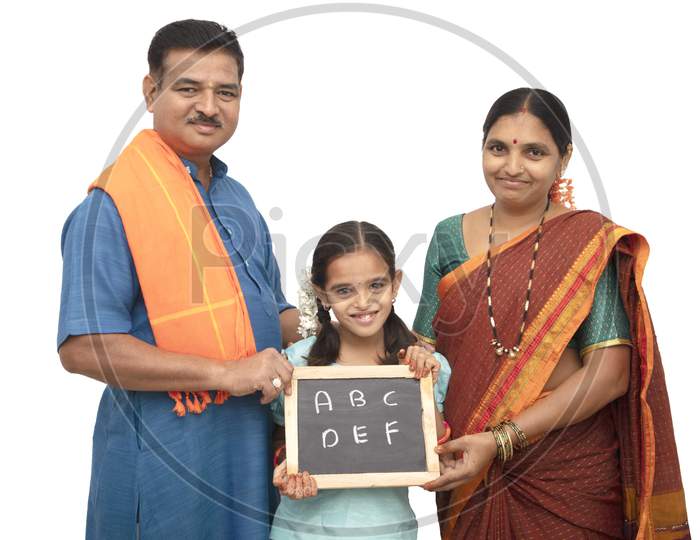 A Happy Three membered Indian family with a kid holding a Slate isolated with White Background