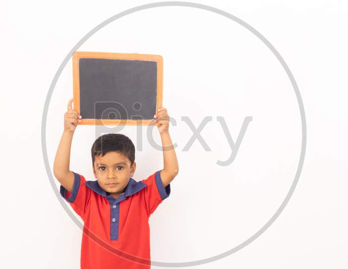 Concept Of Child Protest Showing With Young Boy Holding Black Slate On Isolated Background.