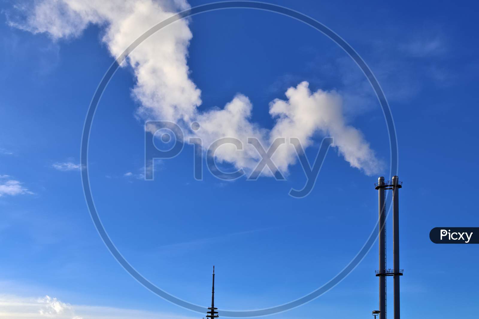 Industry Pollution From Factory Smoestacks In A Deep Blue Sky
