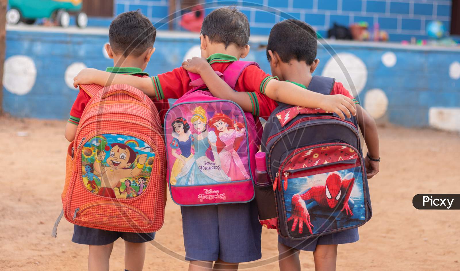 Back View of a couple of Kindergarten Kids with Bags Holding each Other Hands