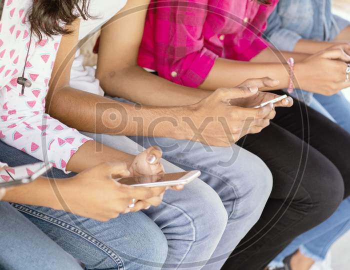 A Group of Young People using Mobile Phone or Smartphone At Outdoors