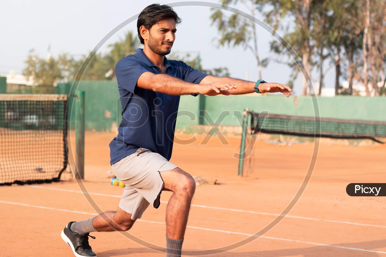 Young Indian Man doing exercise in a Tennis Court