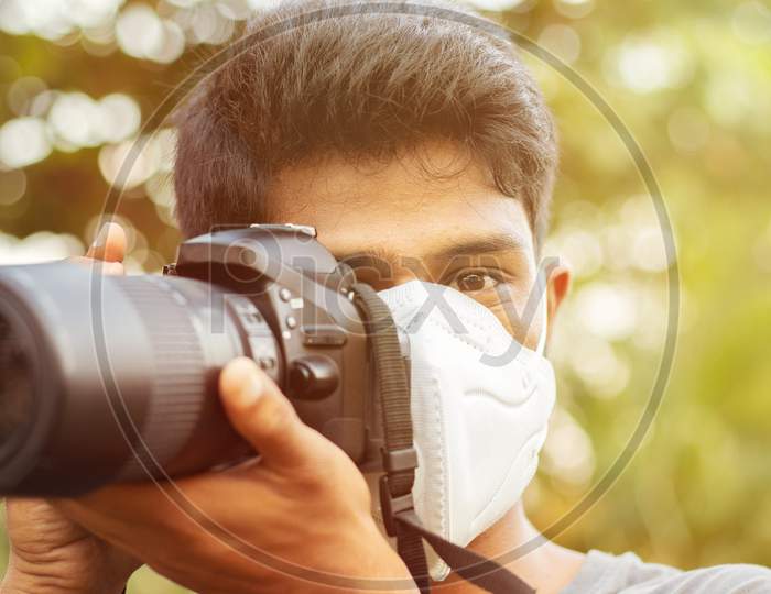 Young Photographer With Pollution Mask - Concept Of Photojournalism And Its Risk.