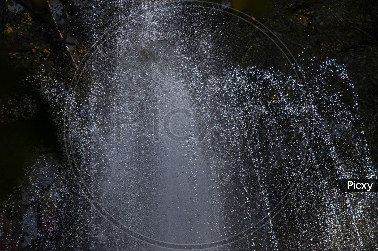 A Water Fountain In Action In The Evening
