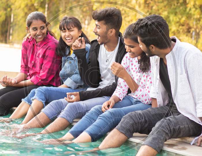 A Group of Happy Young People Talking to each other At Outdoors in a Pool