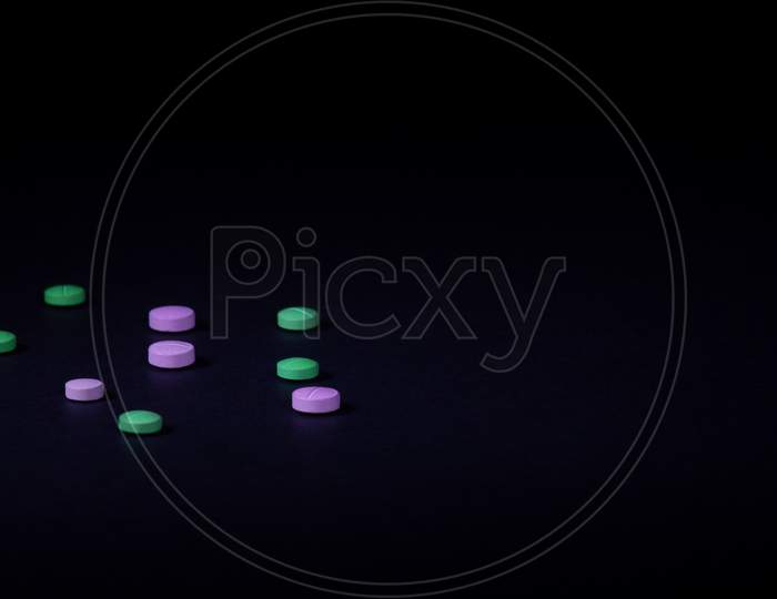 Colored Pills On Black Background. Illegal Drug Concept. Selective Focus With Copy Space.