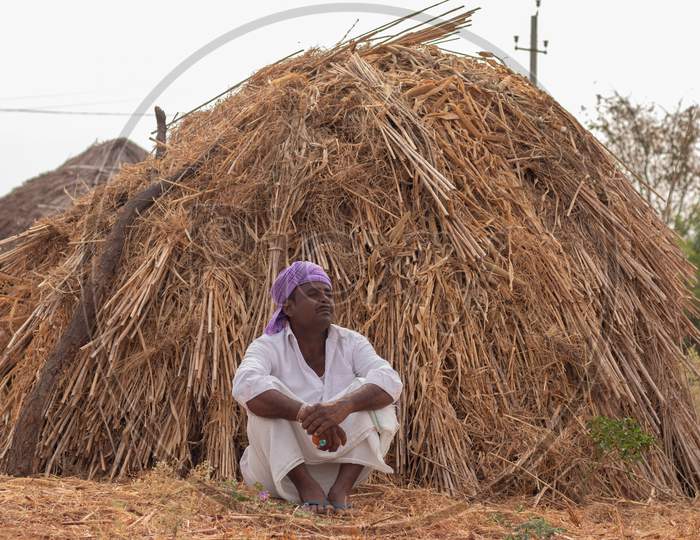 A Rural Indian Farmer with Hay in the Background