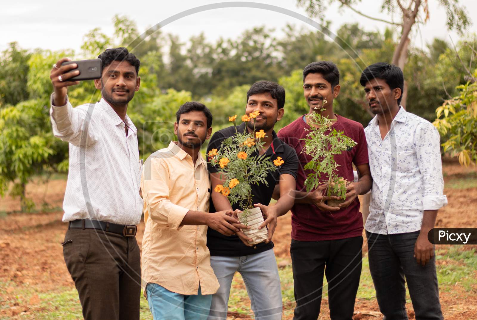 Group of Young People taking a selfie with Plants in Hands