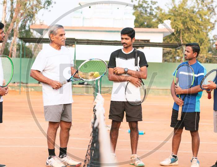 An Experienced or Old Tennis Player talking to the Young Players