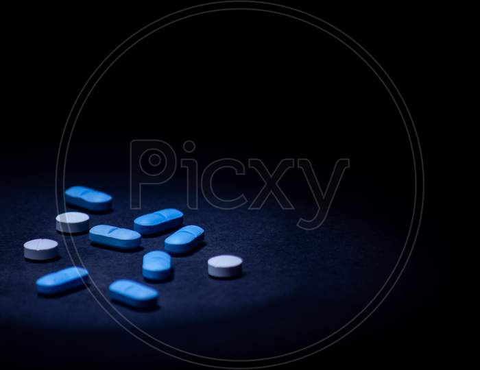 Colored Pills On Black Background. Illegal Drug Concept. Selective Focus With Copy Space.