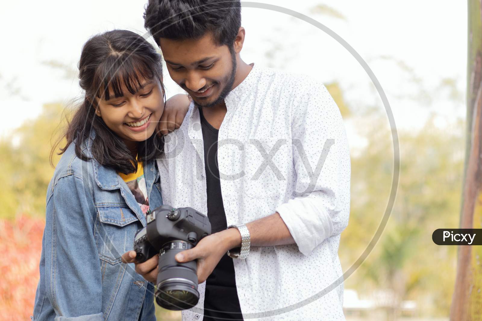 A Couple looking Photos in a DSLR Camera