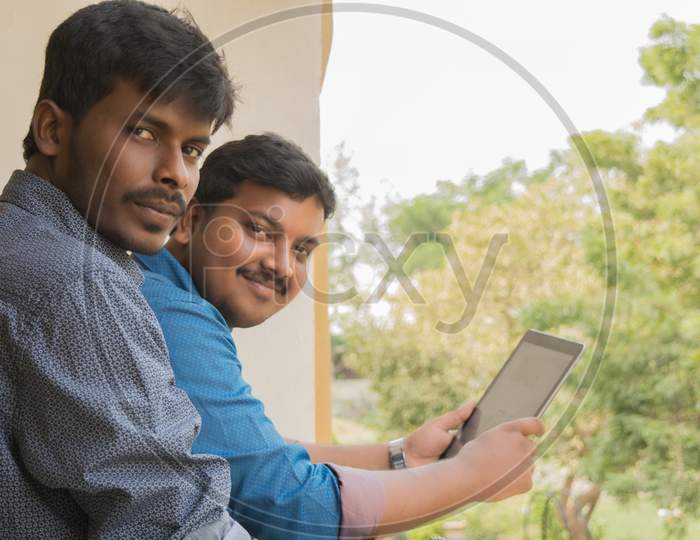 A couple of Happy Indian Men's with Laptop posing towards the Camer