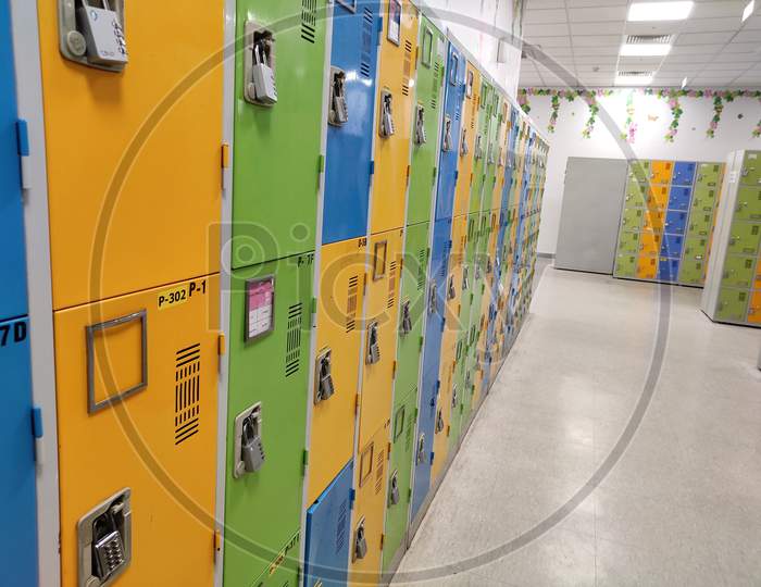 Many colourful locked lockers in locker room.