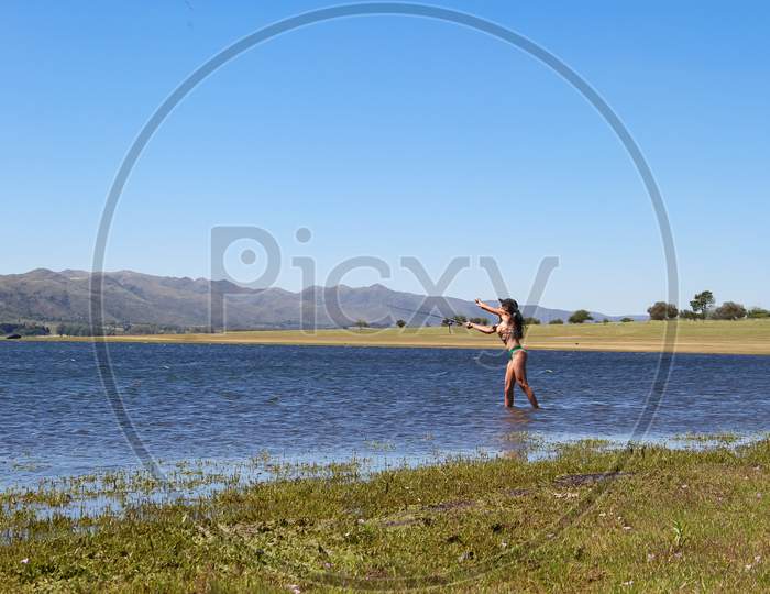Beautiful Young Woman Fishing The Mountain Lake