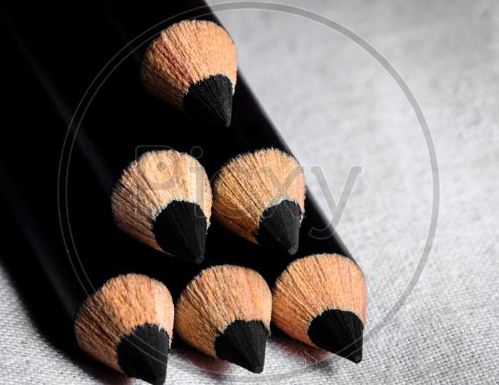 A Group Of Pencils Are Kept One Over Another To Make The Shape Of A Triangle And Focus On The Tips