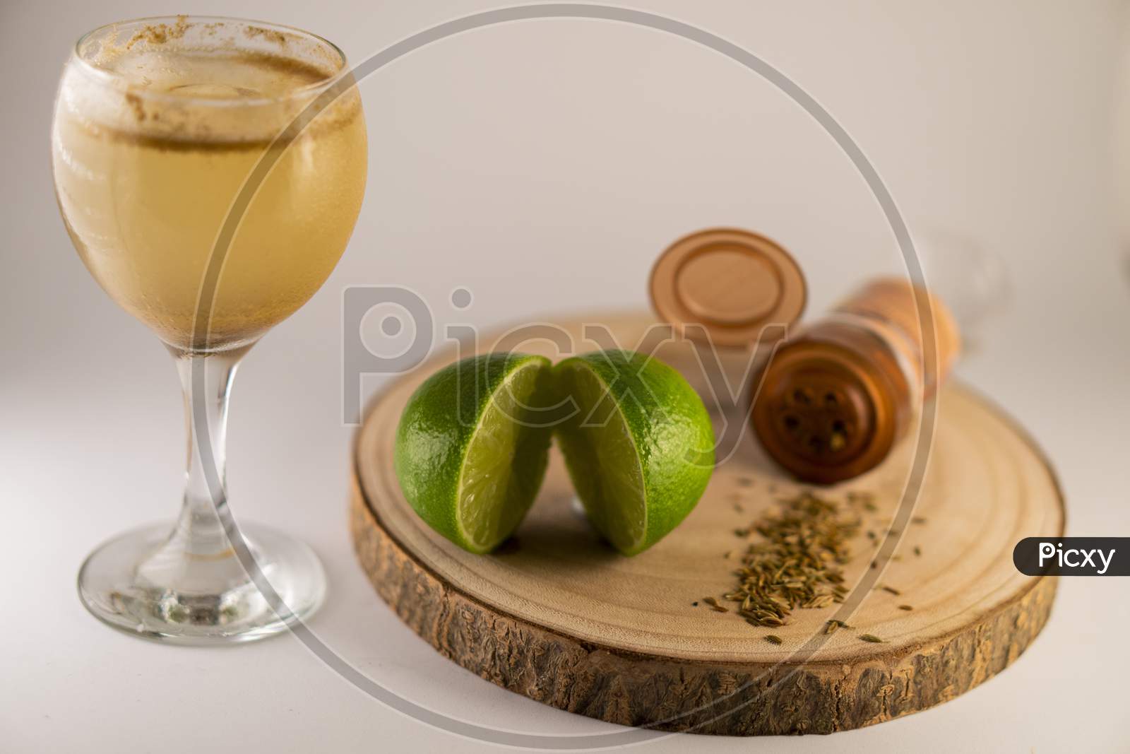 Glass of fresh summer cocktail or mocktail with lemon and herbs garnishing on a white background.