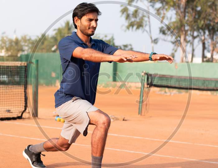 Young Indian Man doing exercise in a Tennis Court