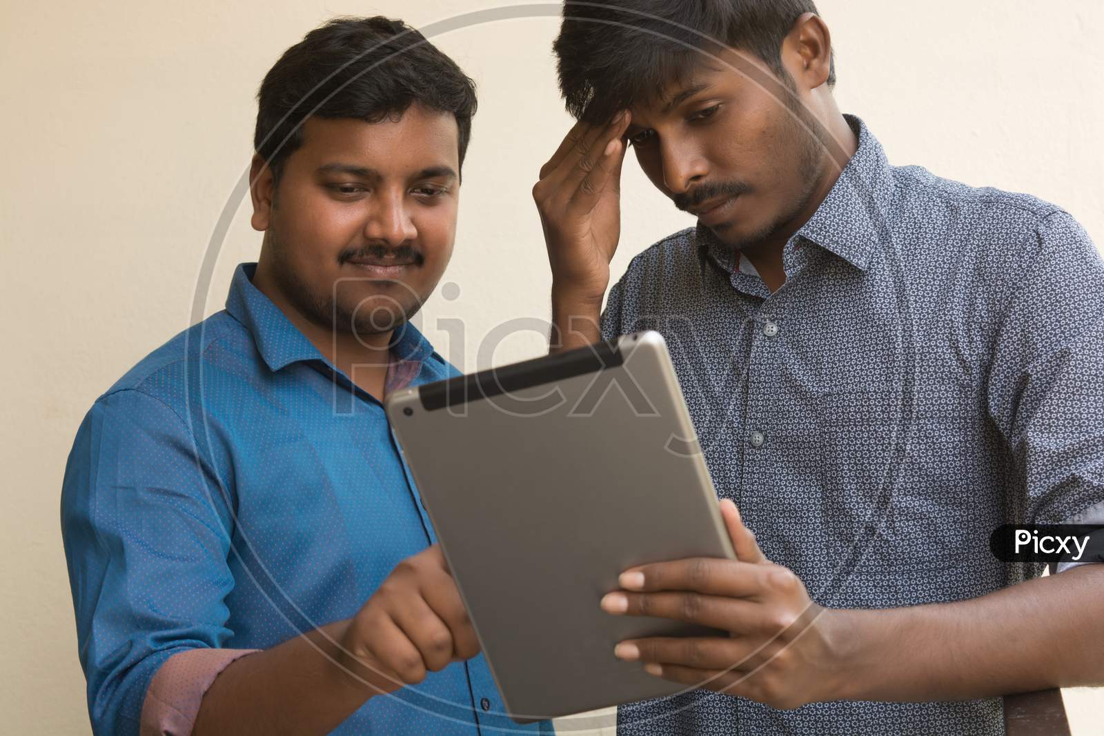 A Couple Of Young Indian Mens Using Tablet Gadget