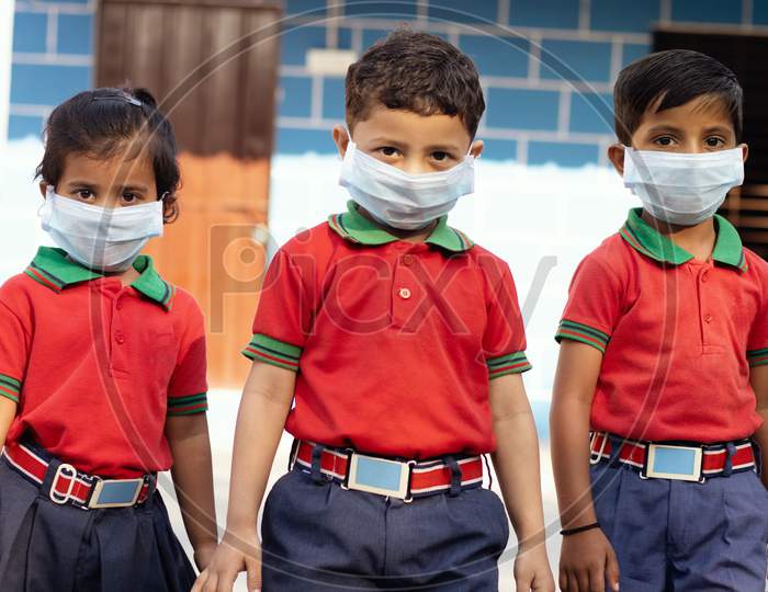 Kids walking in School With Medical Face Mask Wearing Due To Covid-19 Or Coronavirus Outbreak Or Pandemic