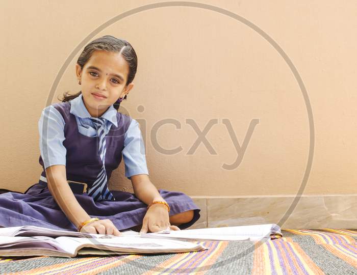 A Beautiful Young Girl Reading With School Dress At Home - School Kid Doing Home Work - Girl Kid With Books And Uniform.