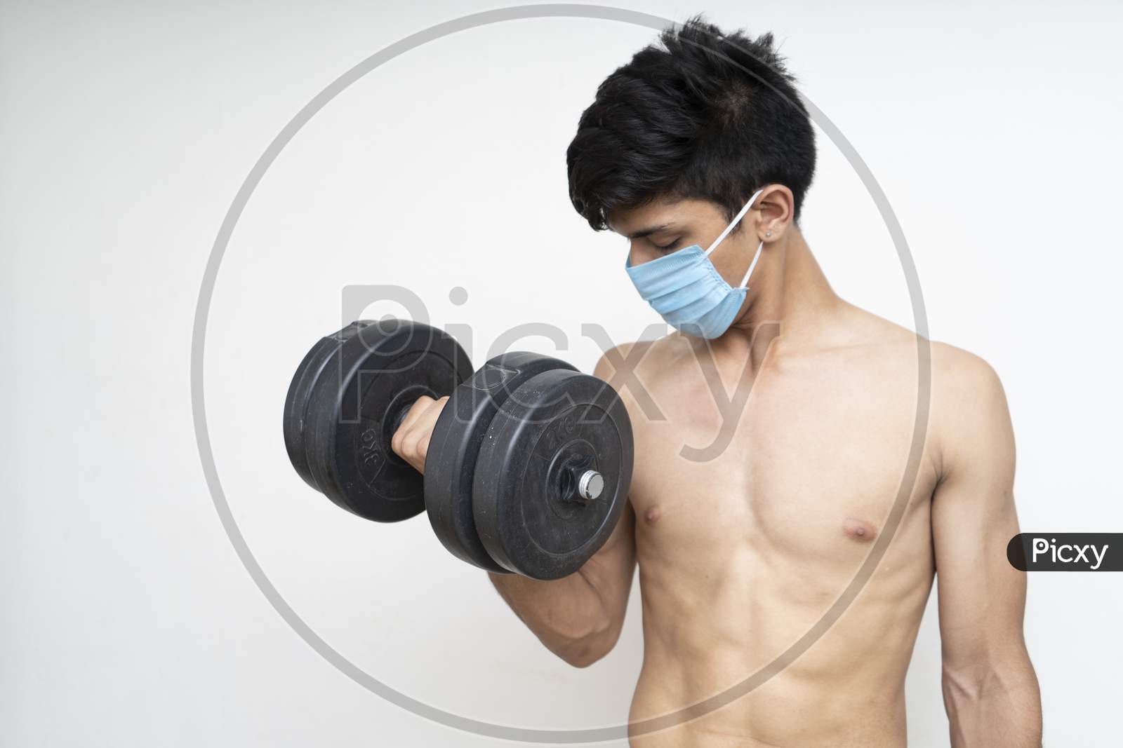Fitness Man With Mask For Epidemic Protection Working Exercise For Arm,Biceps, And Shoulders With Dumbbells.Training In Epidemic Timefitness Man With Mask For Epidemic Protection Working Exercise For Arm,Biceps, And Shoulders With Dumbbells.Training In Epidemic Time